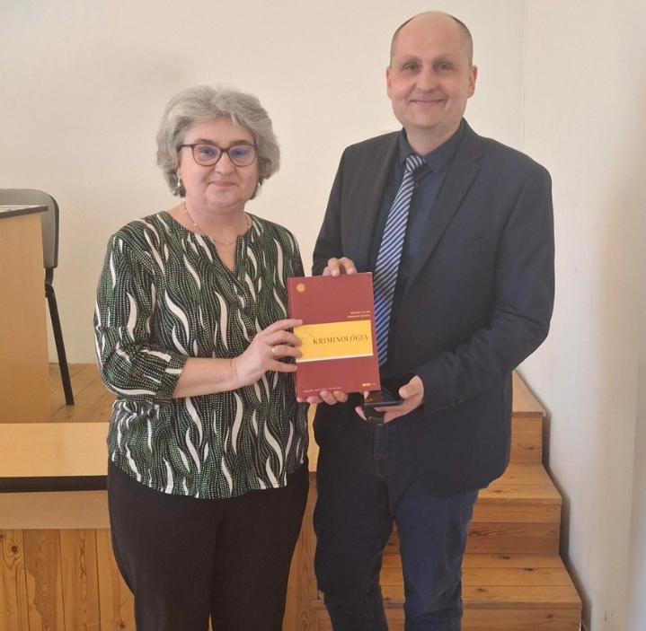 Prof. Dr. Domokos Andrea és Dr. Bérces Viktor közös fotója a Kriminológia tankönyvükkel.