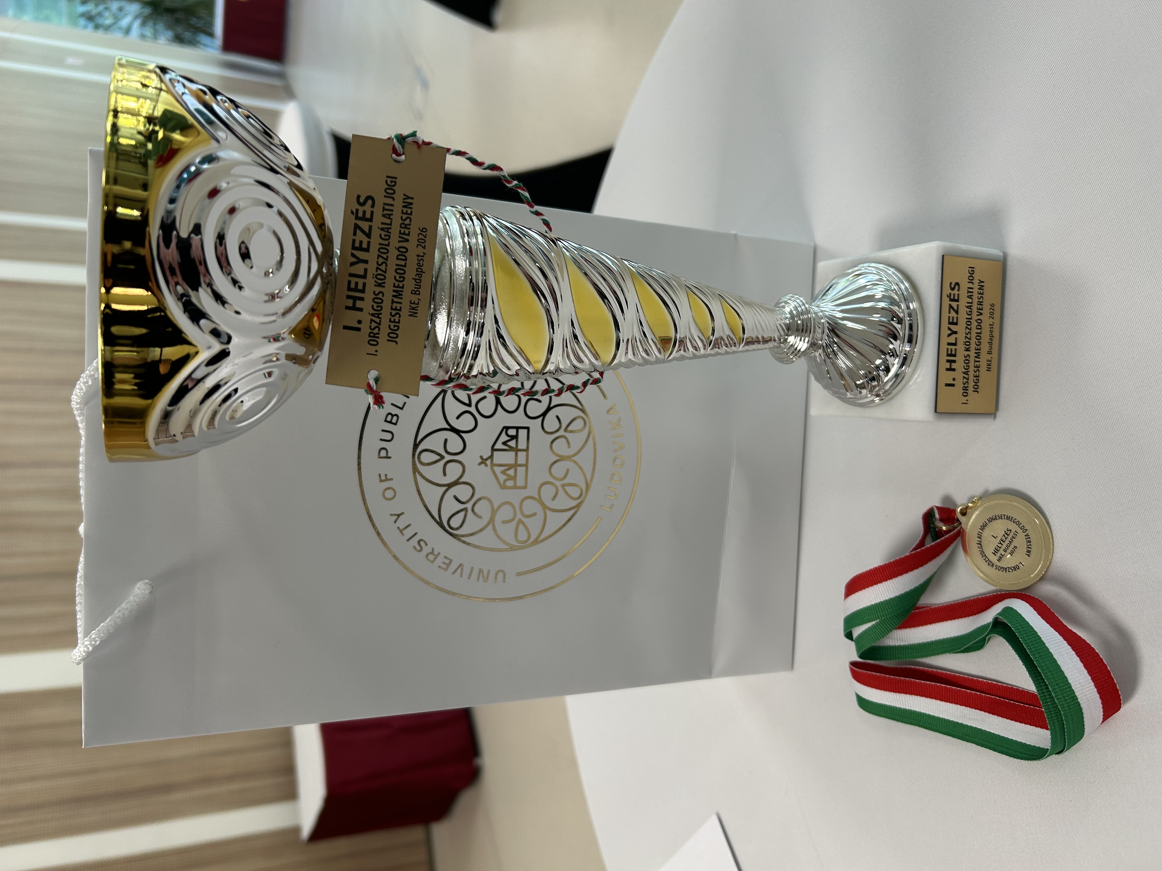 A képen az I. Közszolgálati jogi Jogesetmegoldó Verseny kupája látható.